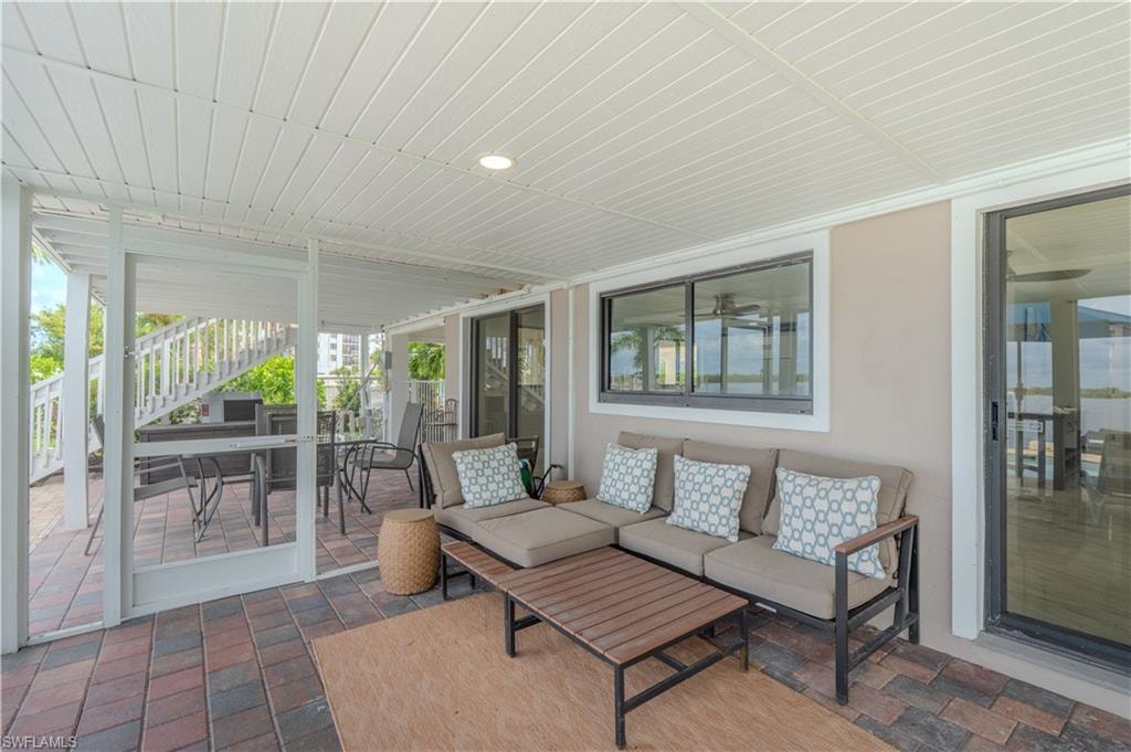 Sunroom featuring outdoor dining space, a patio, and an outdoor hangout area - Virtually Edited Image