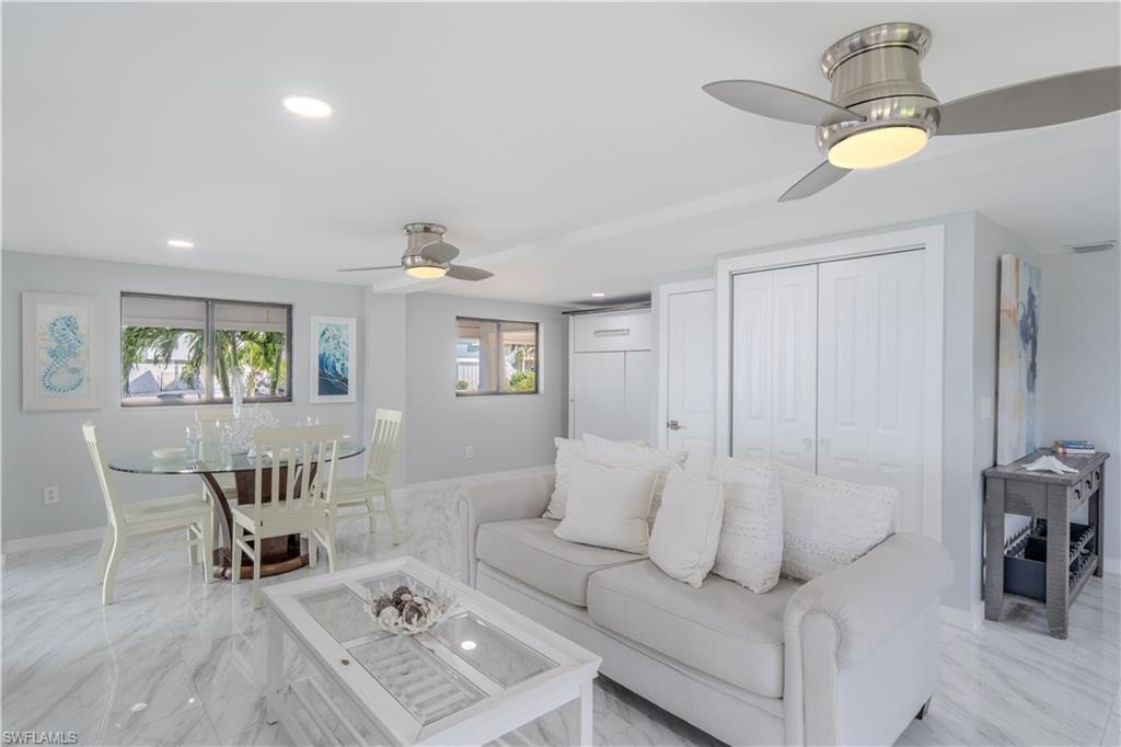 Living area featuring a ceiling fan, recessed lighting, plenty of natural light, and light tile finish flooring - Virtually Edited Image