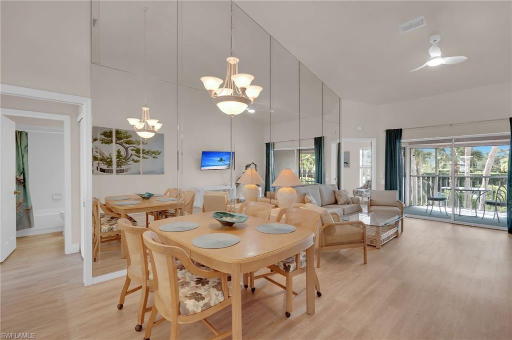 Dining space featuring light wood-style floors, a chandelier, and a towering ceiling