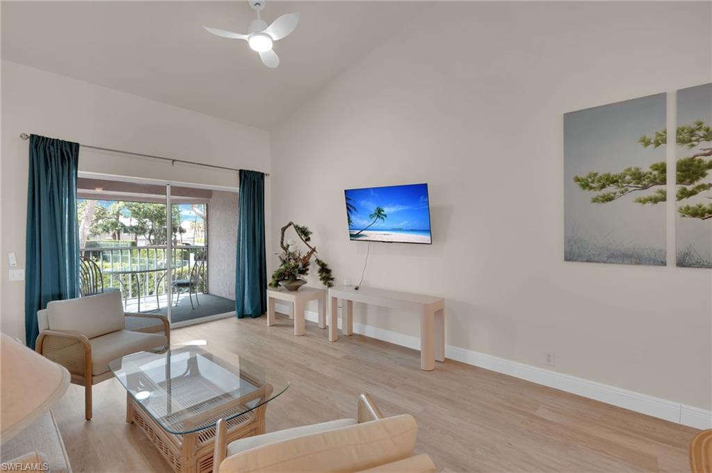 Living area with vaulted ceiling, light wood-style flooring, and ceiling fan