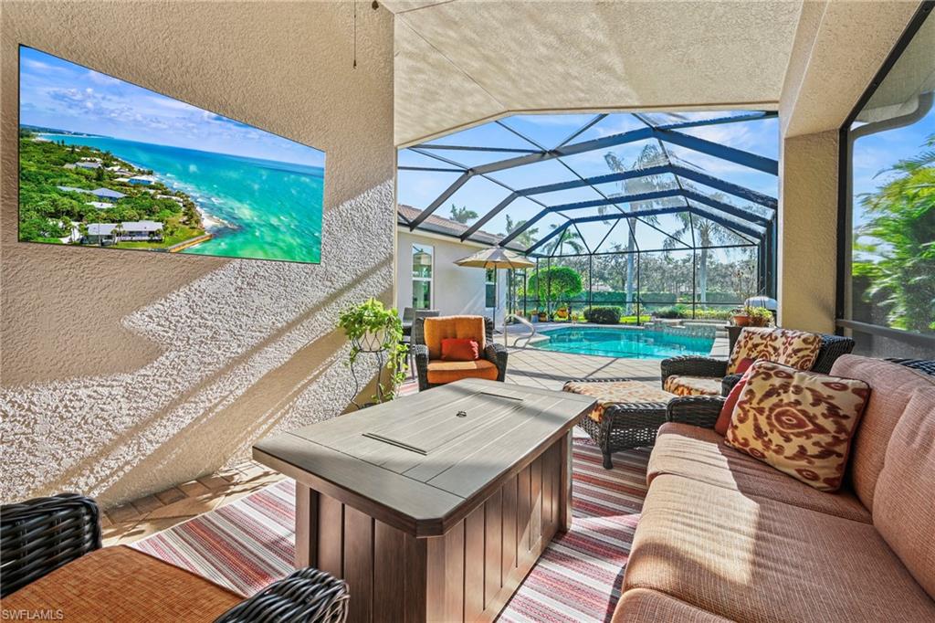 View of patio featuring a sunroom, an outdoor pool, glass enclosure, and an outdoor hangout area