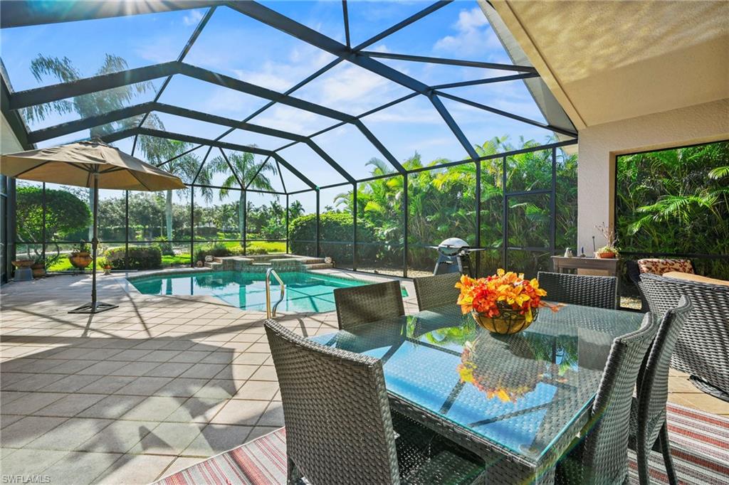 View of pool featuring outdoor dining space, glass enclosure, and a sunroom