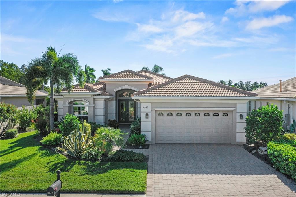 Mediterranean / spanish home with stucco siding, a front yard, decorative driveway, and a tiled roof