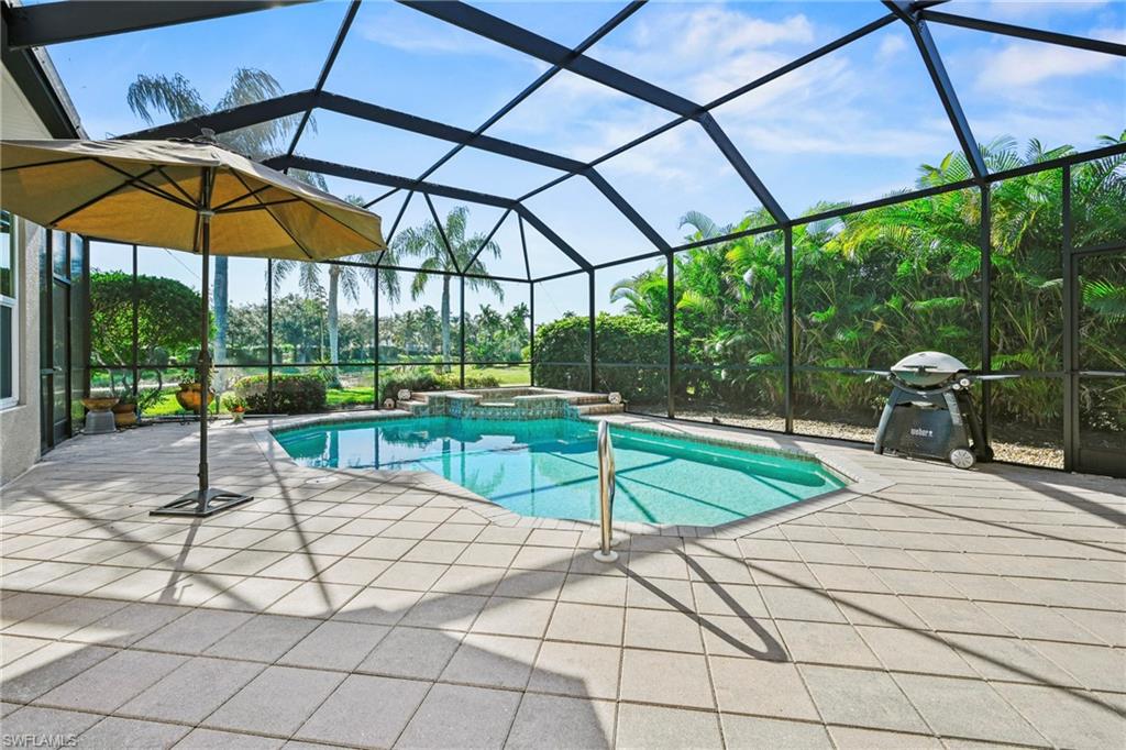 View of swimming pool with a sunroom, a lanai, grilling area, a pool with connected hot tub, and a patio