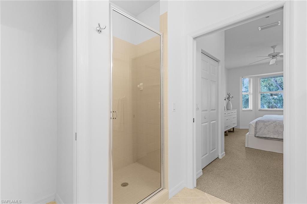 Primary en-suite bathroom featuring tile patterned floors, shower with separate bathtub, and double vanities.