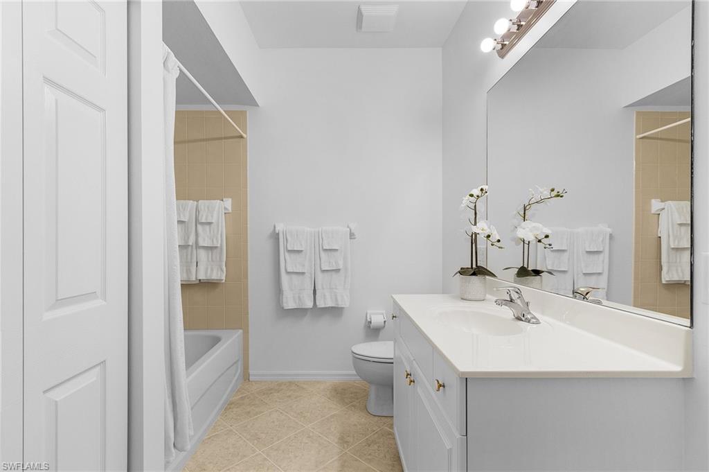 Full bathroom off main hall with tile patterned floors, shower/tub combination and laundry closet.