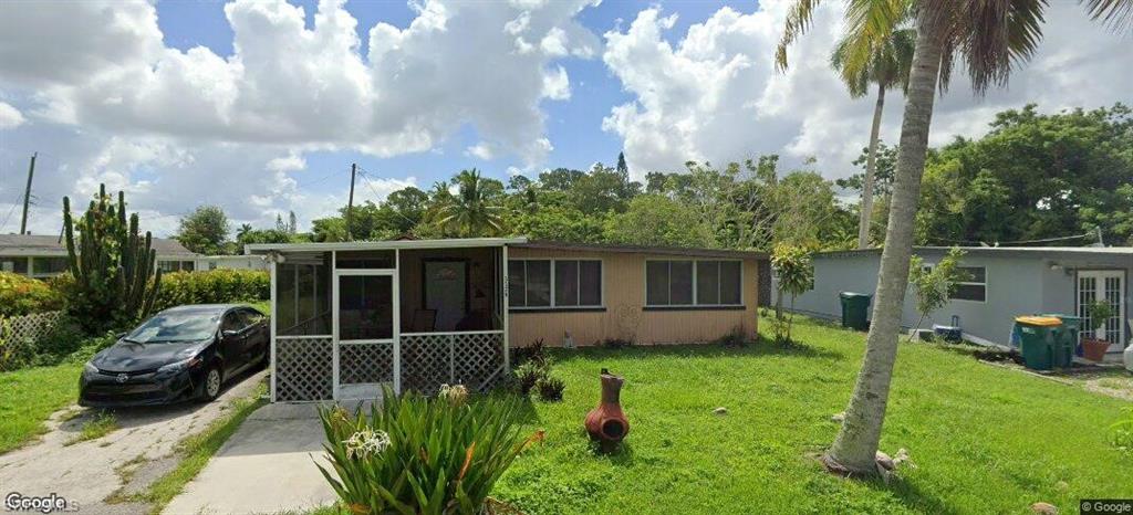 View of front of house with a front lawn and a sunroom