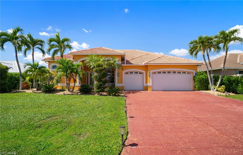 Mediterranean / spanish-style house featuring a garage, a front yard, stucco siding, driveway, and a tile roof