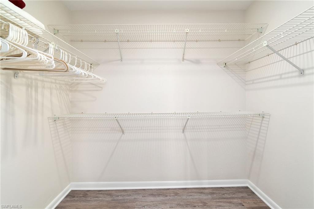 Spacious closet with dark wood-style floors