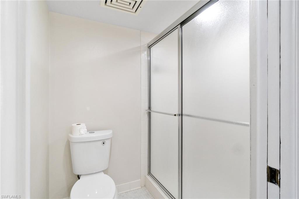 Bathroom with a shower stall and toilet