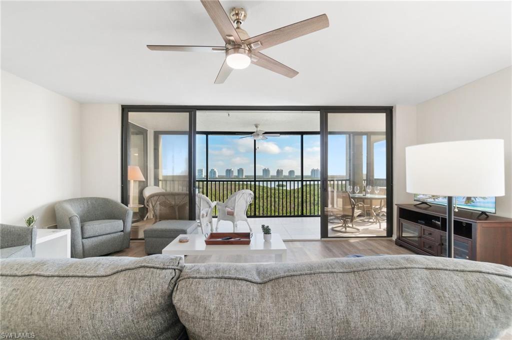 Living area featuring expansive windows, wood finished floors, and a ceiling fan