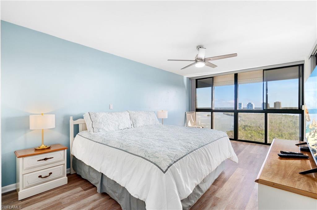 Bedroom featuring floor to ceiling windows, light wood-style floors, and ceiling fan