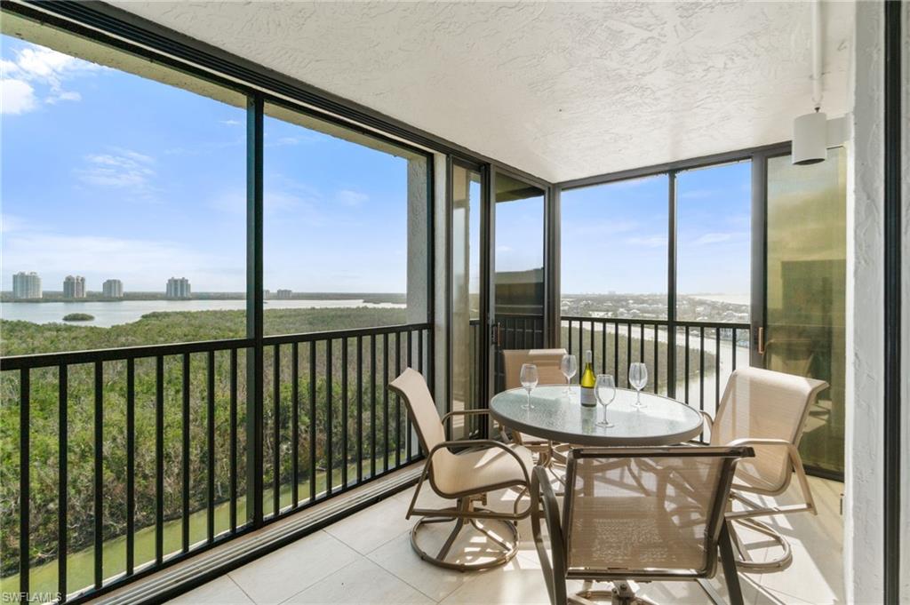 Sunroom featuring floor to ceiling windows, a water view, tile patterned flooring, and a textured ceiling