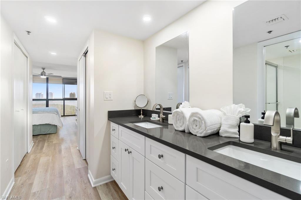 Ensuite bathroom featuring light wood-style floors, double vanity, ceiling fan, and recessed lighting