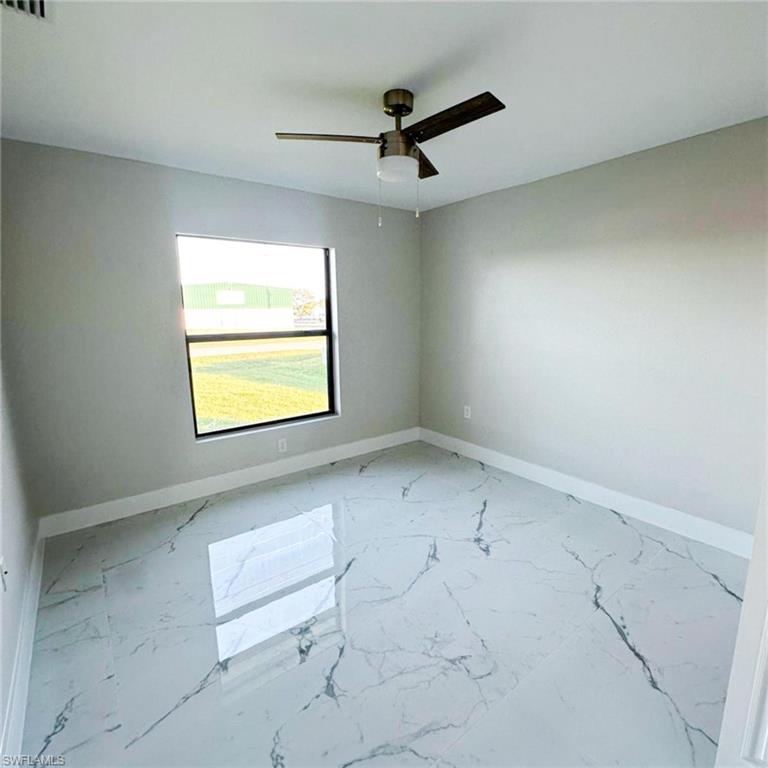 Spare room featuring baseboards and light marble finish floors