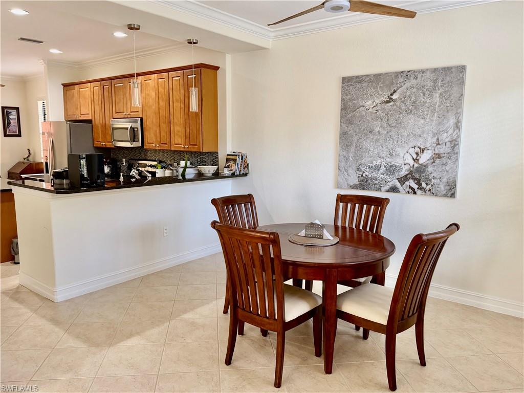 Dining room with ornamental molding, light tile patterned floors, ceiling fan, and recessed lighting
