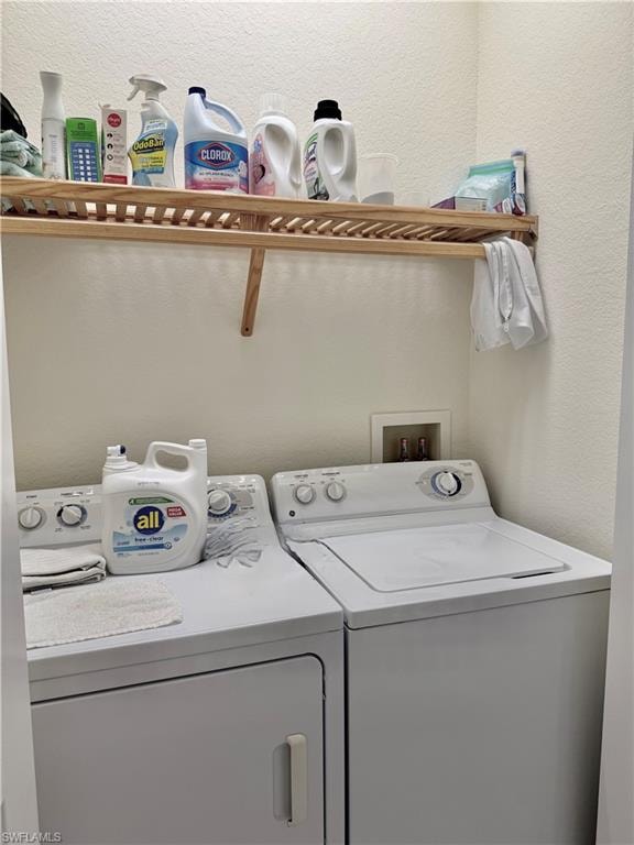 Washroom with a textured wall and washer and clothes dryer
