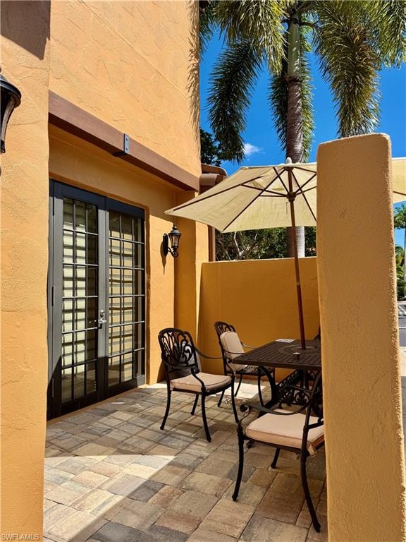 View of patio with french doors and outdoor dining area