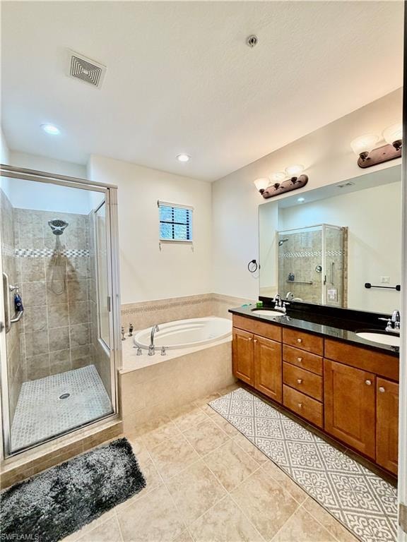 Full bathroom featuring double vanity, a stall shower, a garden tub, and light tile patterned floors