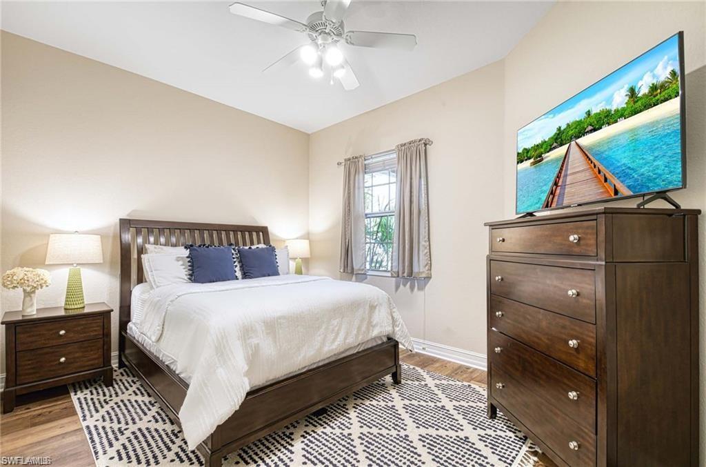 Guest bedroom with wood grain luxury vinyl, lighted ceiling fan and oversized double closet.