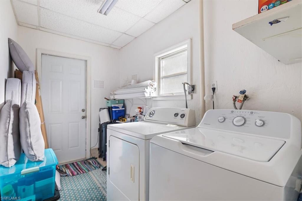 Laundry room with a paneled ceiling and washer and clothes dryer