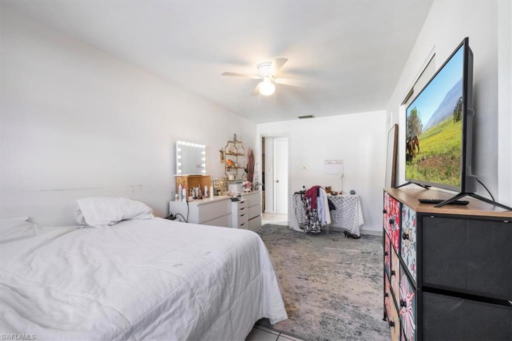 Bedroom featuring a ceiling fan and tile patterned floors