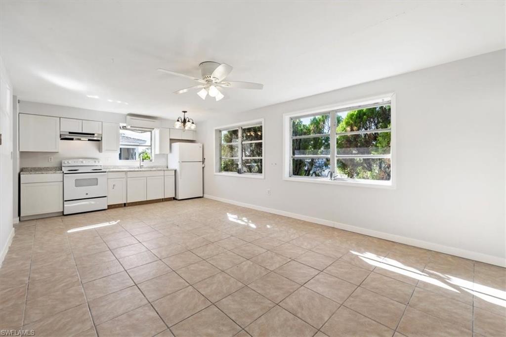Kitchen featuring white appliances, white cabinetry, light countertops, and light tile patterned floors
