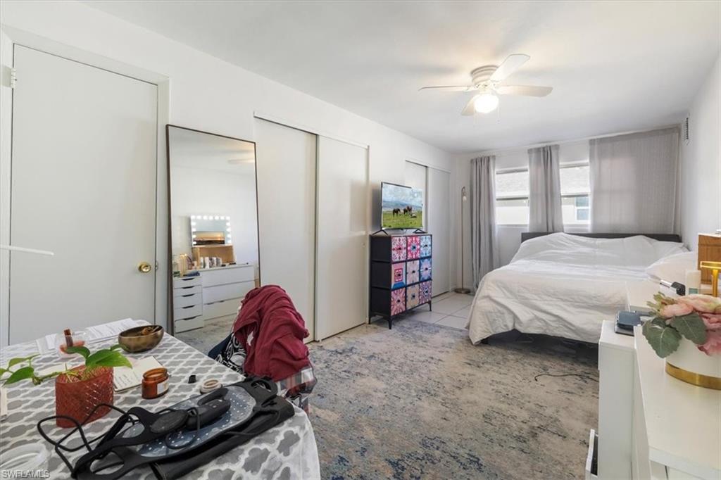 Bedroom featuring two closets, ceiling fan, and carpet floors