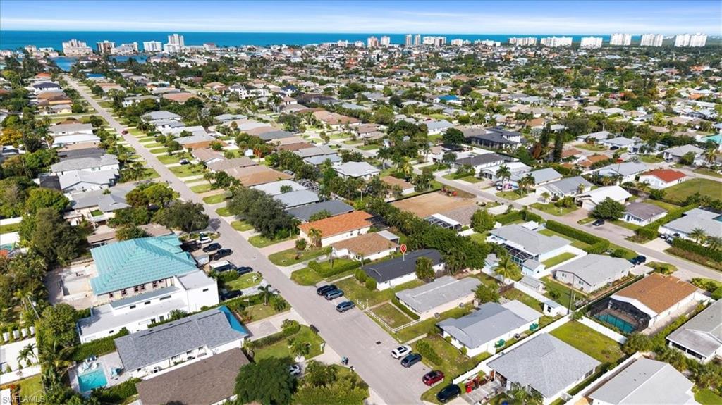 Aerial view of property and surrounding area with nearby suburban area and a large body of water