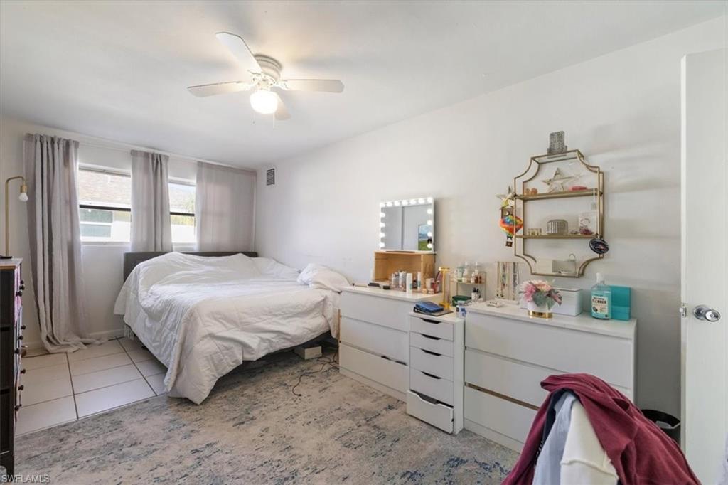 Bedroom with light tile patterned floors and ceiling fan