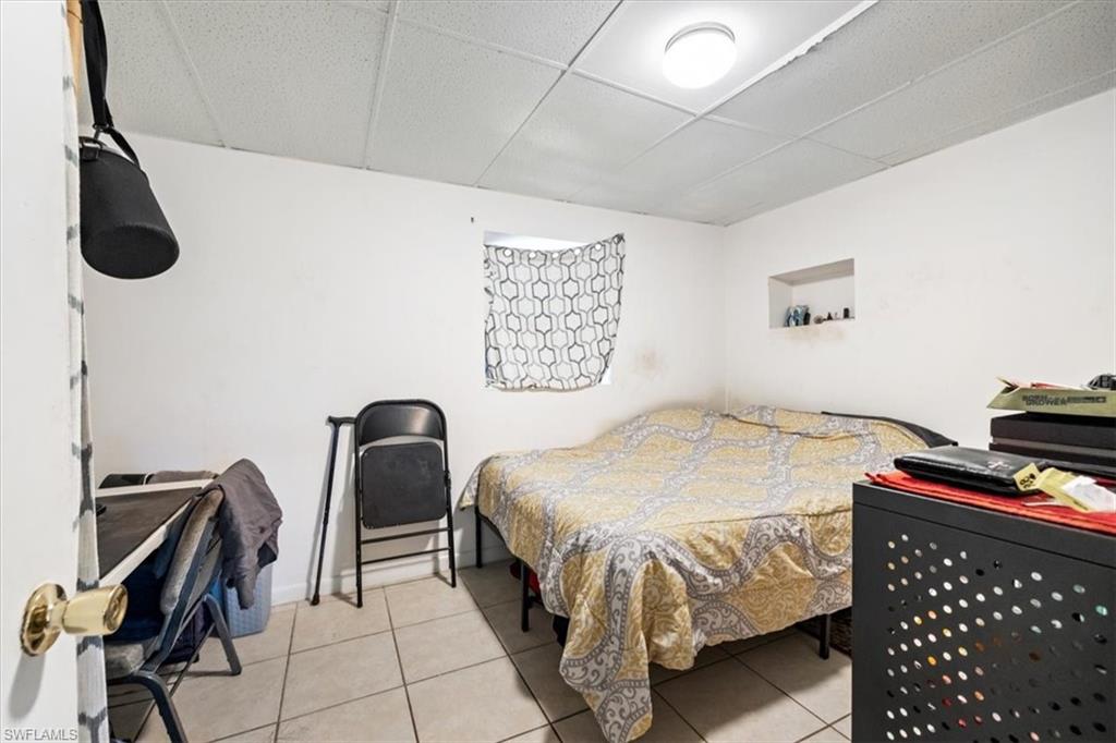 Bedroom featuring a drop ceiling and light tile patterned flooring