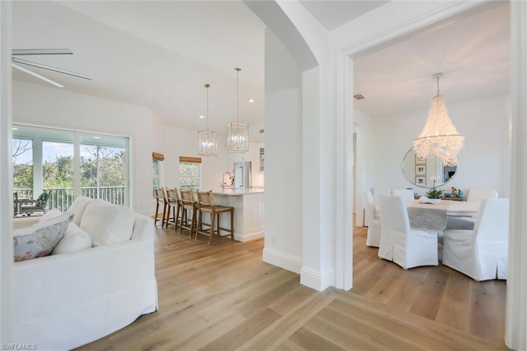 Living room with a notable chandelier, sink, and light wood-type flooring