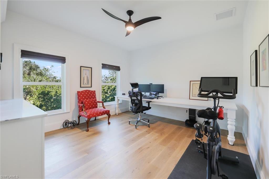 Office area with ceiling fan and light hardwood / wood-style floors