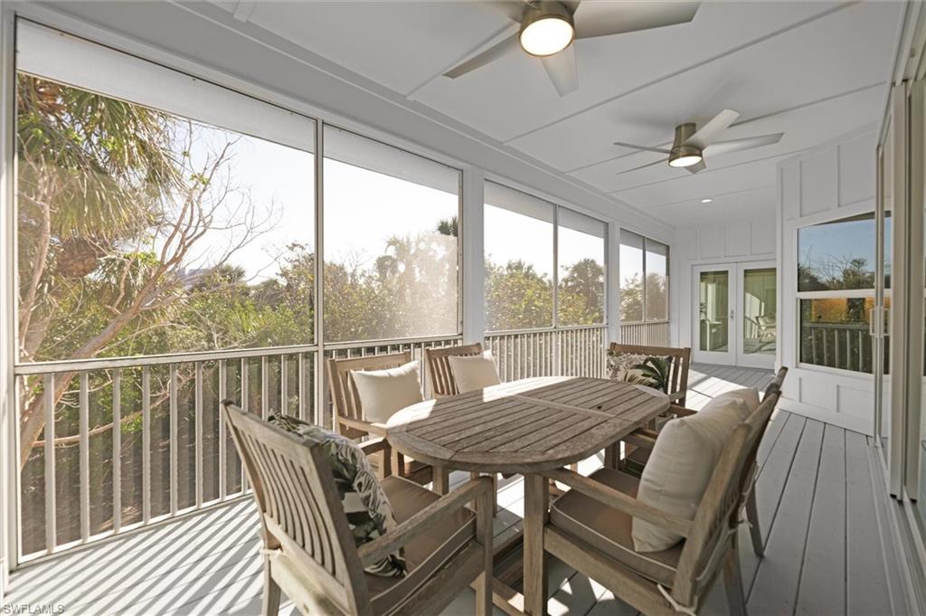 Screened lanai with ceiling fans overlooking tropical landscaping