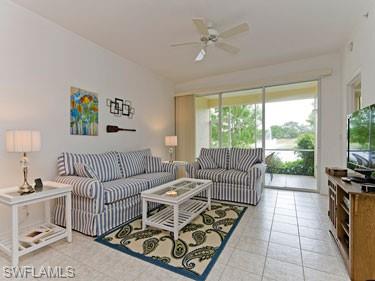 Living room featuring light tile patterned flooring and a ceiling fan