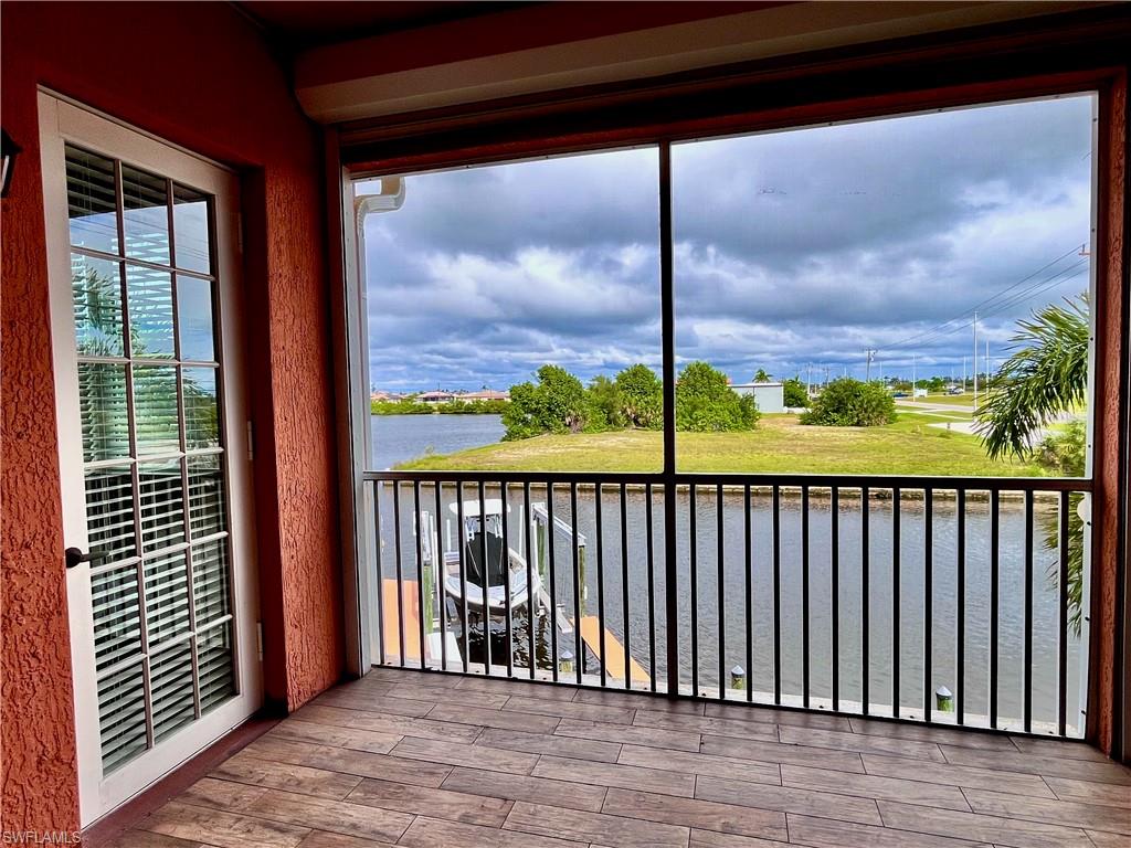 Second floor screened in balcony featuring a water view