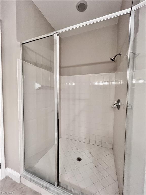 Full bath with a stall shower and tile patterned flooring