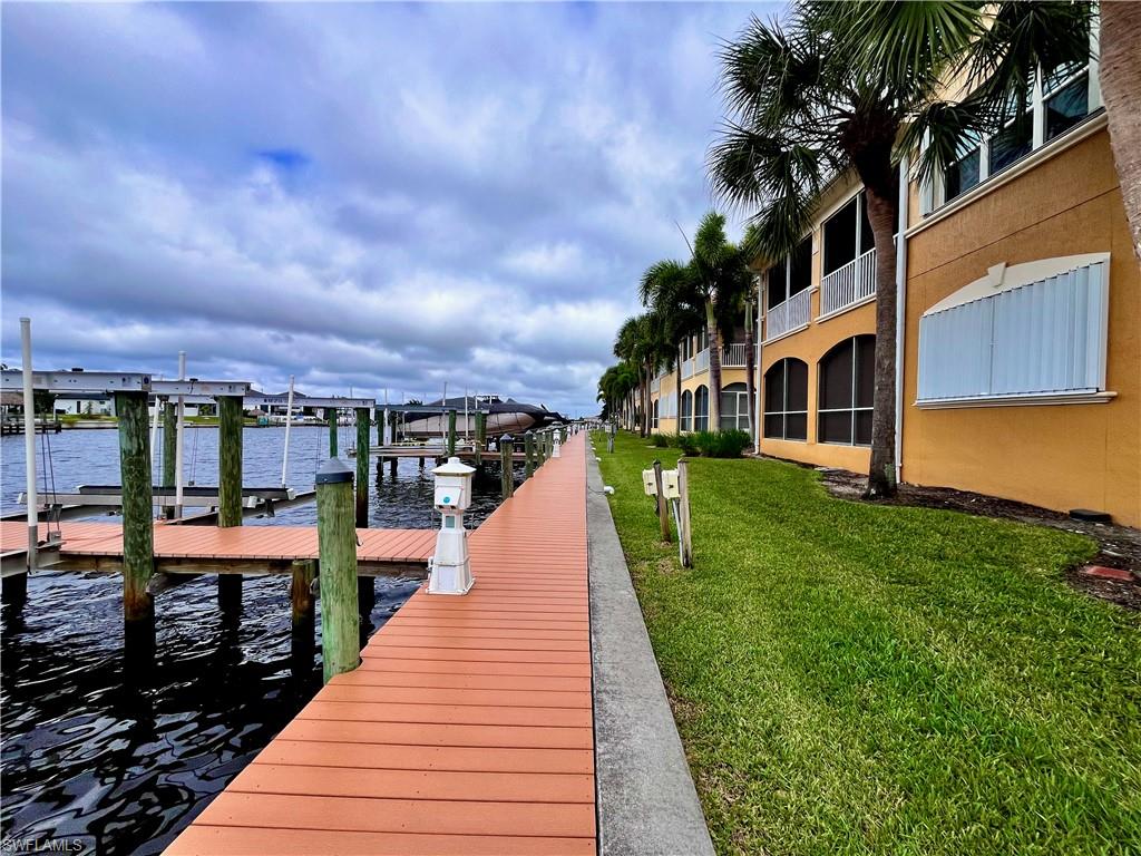 Boardwalk area encircling the community for walking, enjoying the sunset or fishing -  featuring a water view, a lawn, and boat lift to rent