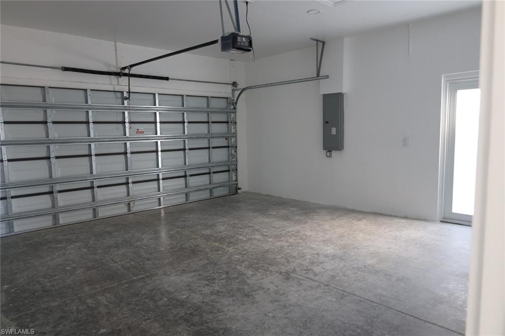 Garage featuring electric panel and a garage door opener