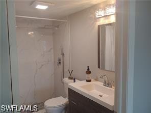 Full bath with vanity and a marble finish shower