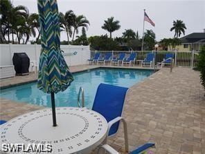 Community pool featuring a fenced backyard and a patio