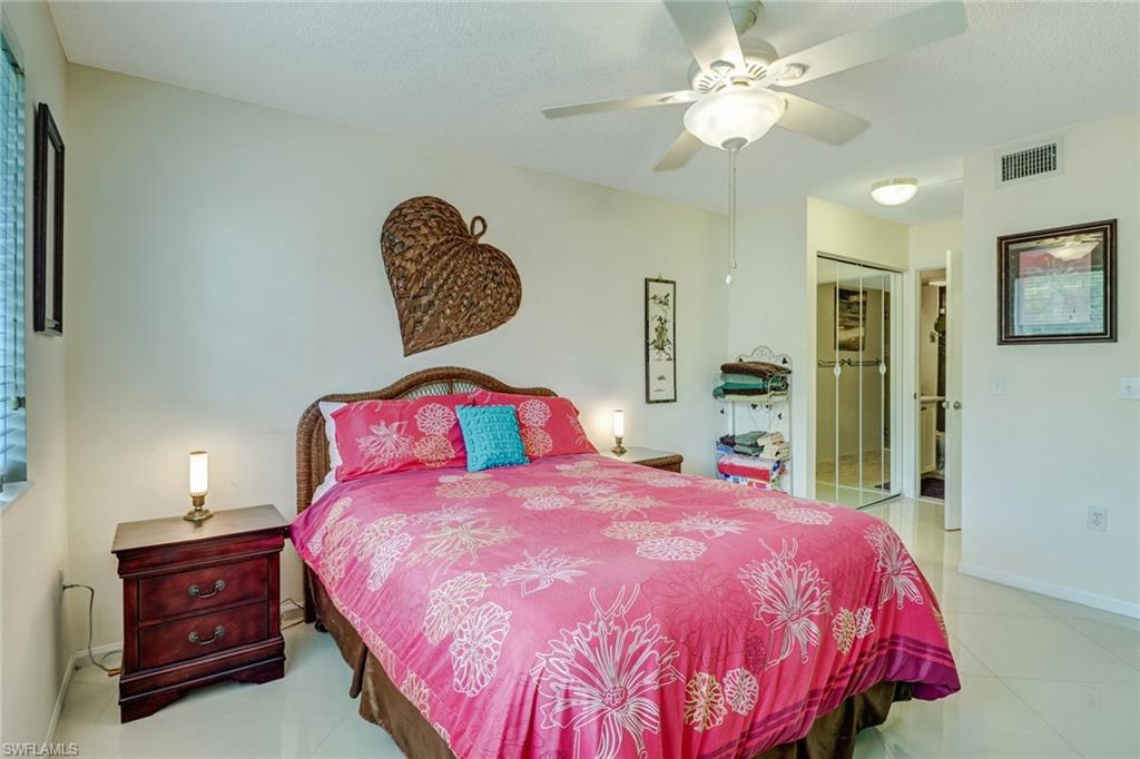 Bedroom with a closet, light tile patterned floors, and a ceiling fan