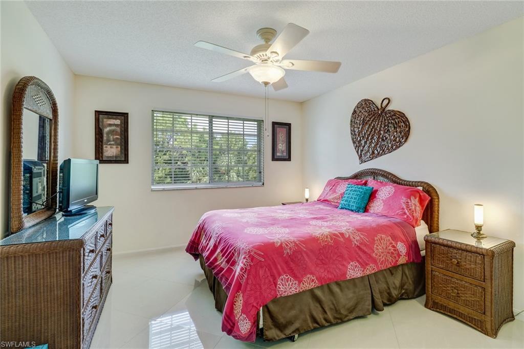 Bedroom featuring ceiling fan, light tile patterned flooring, and a textured ceiling