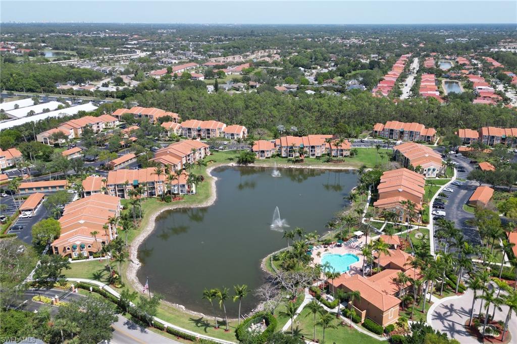 Aerial view of property and surrounding area featuring a large body of water and apartment complex