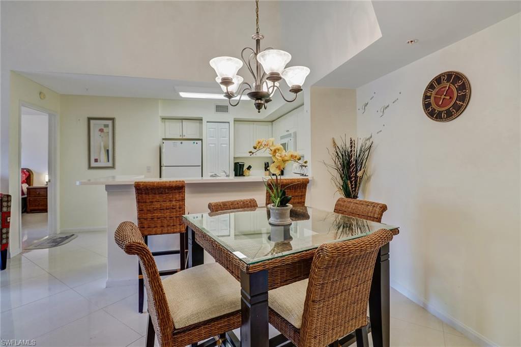 Dining area with light tile patterned flooring and a chandelier