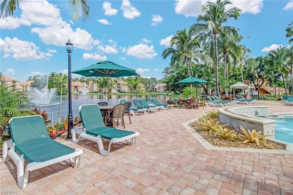 View of patio featuring a community pool and a water view