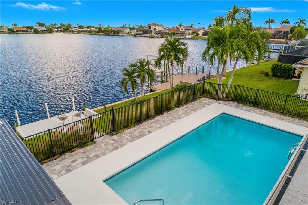 View of swimming pool featuring a patio area, a water view, and a residential view