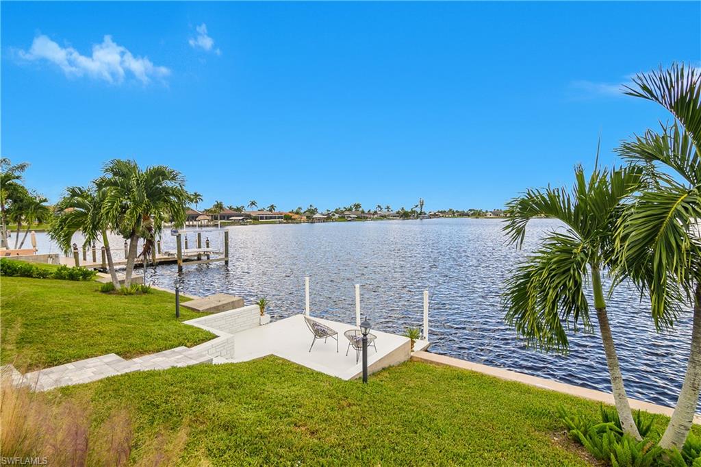 Dock area with a lawn and a water view