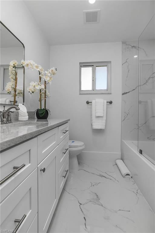 Full bathroom with vanity, a combined bath / shower with marble appearance, and light marble finish flooring