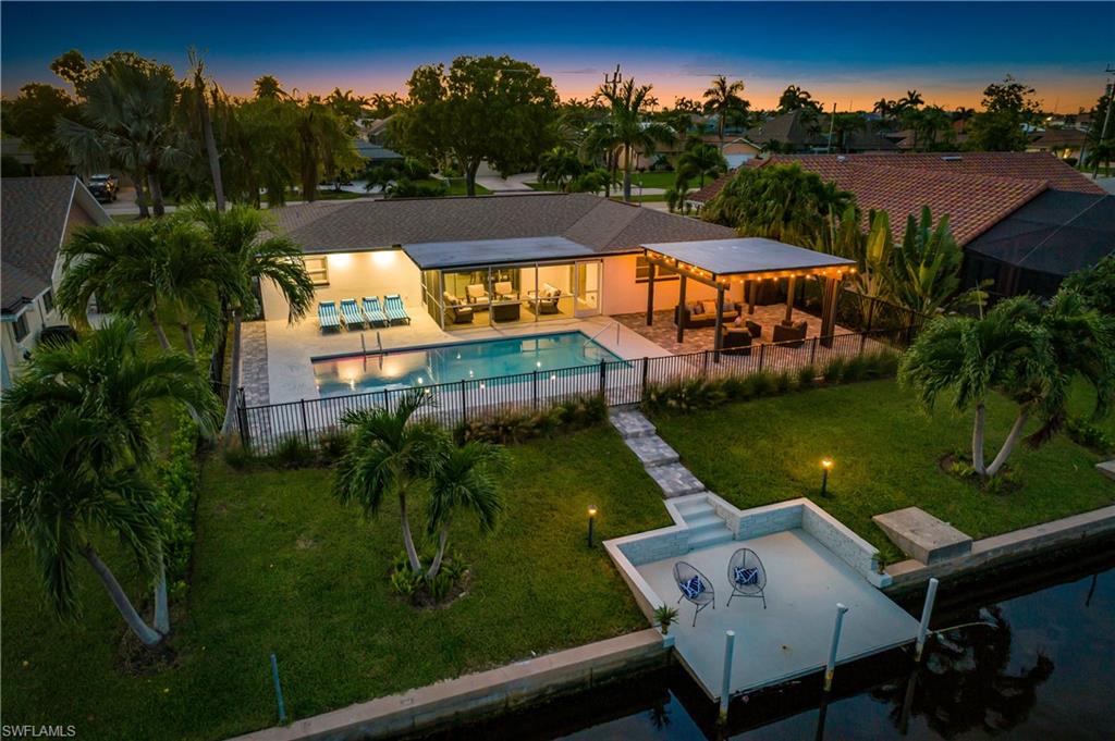 Back of house at dusk featuring a fenced backyard, a patio, and an outdoor hangout area